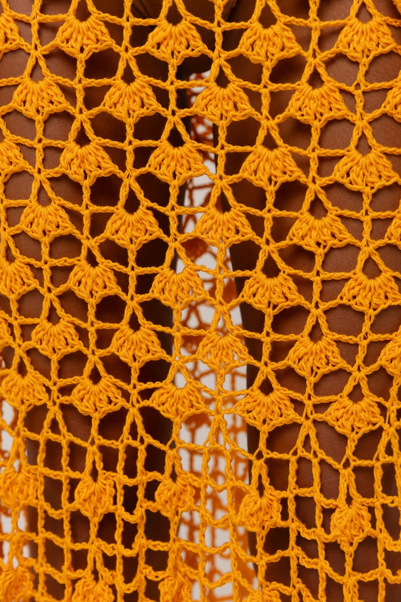 Handmade orange crochet shirt featuring California poppy design by Andreeva, shown on a model with a relaxed fit.