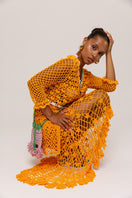 Orange handmade crochet shirt featuring California poppy design by Andreeva, displayed on a hanger.