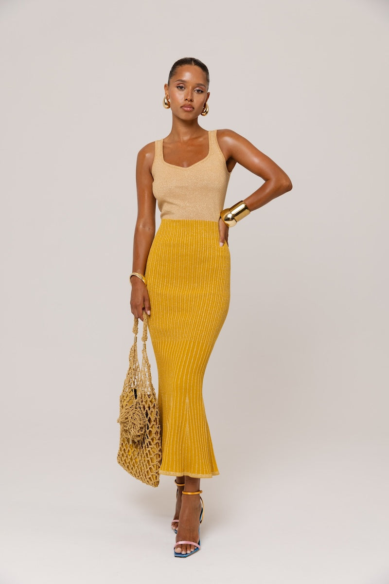 Golden Hour metallic knit maxi dress by Andreeva, showcasing a shiny, fitted design with long sleeves and a flowing silhouette.