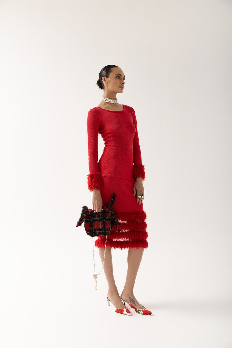 Red knit top with handmade knit details from Andreeva, showing close-up of textured fabric and stylish design.