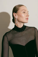 Silver Eugenia Ospina Origen earrings with intricate design and polished finish displayed against a neutral background.