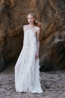 White AQUA maxi dress by OVERTHESEA, flowing fabric with a relaxed fit, styled with a V-neck and sleeveless design.
