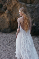 White Aqua maxi dress by OVERTHESEA with flowing fabric and elegant design, shown on a model.