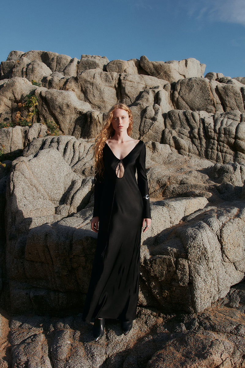 OvertheSea Insomnia black midi dress displayed on a hanger, showcasing its sleek design and elegant length.