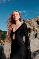 Overthesea black insomnia midi dress displayed on a hanger, showcasing its sleek, elegant design and smooth fabric.