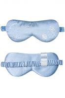 Manito ocean blue silk eye mask resting on a soft surface, designed for comfortable home use and relaxation.