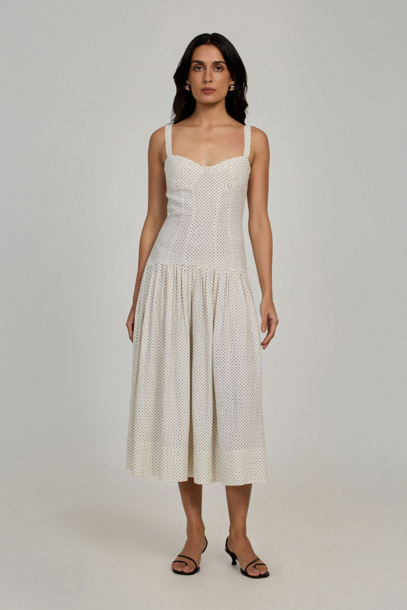 Summer Away Odessa Dress in ivory with dot pattern, midi length, flowing fabric, and sleeveless design for a stylish summer look.