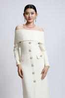 White Valenciani off-shoulder long shift dress displayed on a model, featuring a flowing maxi dress design with elegant off-shoulder style.