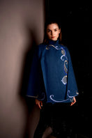 Nadya Shah Olympia denim cape jacket with stylish design, featuring denim fabric and a relaxed fit, displayed on a plain background.