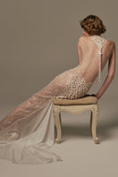 Elegant white POEM Ondine gown displayed on a model, showcasing flowing fabric and intricate design details.