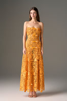 Orange floral garden strapless A-line maxi dress by I.H.F Studio, flowing fabric with a fitted bodice and elegant silhouette.
