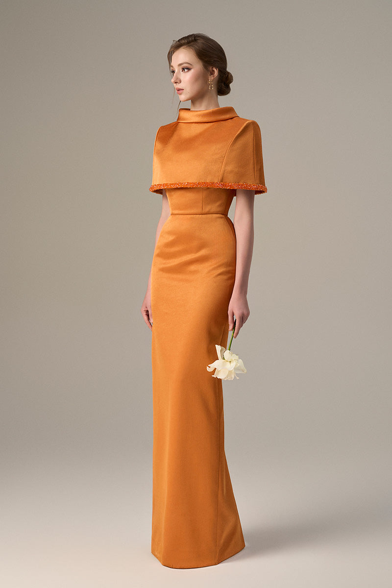 Orange taffeta maxi dress with a cropped cape and inverted lapel, designed by I.H.F, showcased on a model.