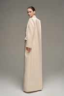 Beige double-breasted long coat by I.H.F Studio featuring an oversized, straight-cut design, displayed on a hanger.