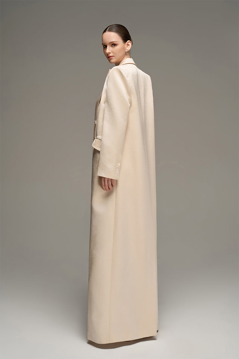 Beige double-breasted long coat by I.H.F Studio featuring an oversized, straight-cut design, displayed on a hanger.