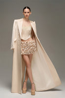 Beige double-breasted long coat by I.H.F Studio with an oversized, straight-cut design, displayed on a mannequin.