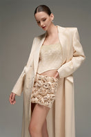 Beige corset top and embroidered skirt set by I.H.F Studio, featuring a coordinated, oversized, long straight-cut coat.