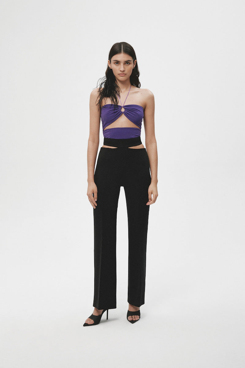 Black JC Pajares pants with stylish cut-outs, showcasing a trendy and modern design on a sleek fabric background.