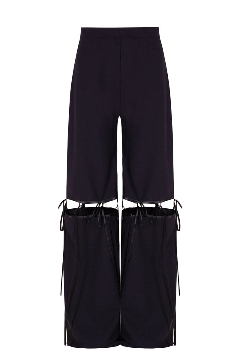 Black multi bow pants by JC Pajares, stylish pants with bow detailing, displayed in a natural pose on a white background.