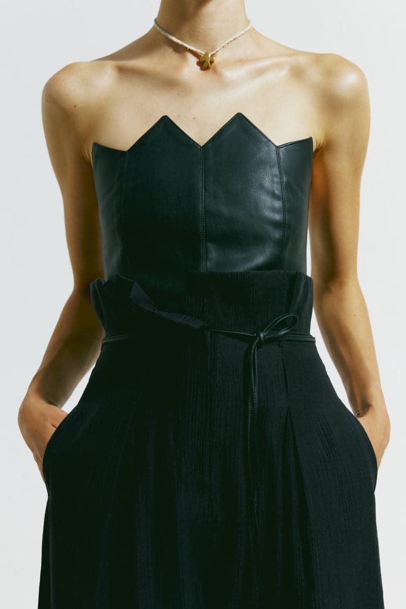 Black scalloped edge corset top by PODYH, featuring a fitted design with decorative scalloped detailing on the edges.