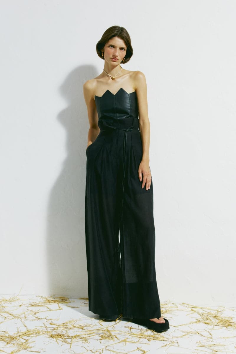 Black scalloped edge corset top by PODYH, featuring structured fit and decorative scalloped detailing, worn styled with fashion-forward clothing.