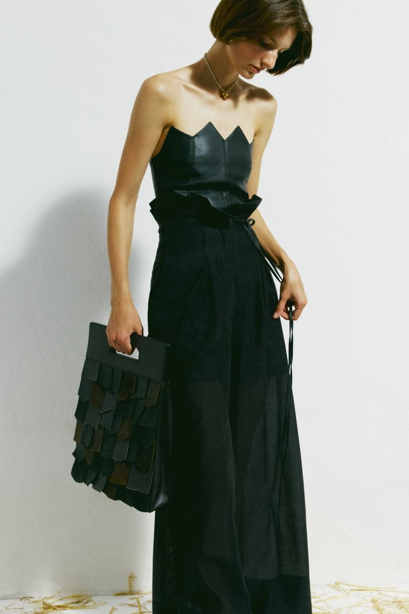 Black scalloped edge corset top by PODYH, featuring a fitted design with scalloped detailing along the edges.