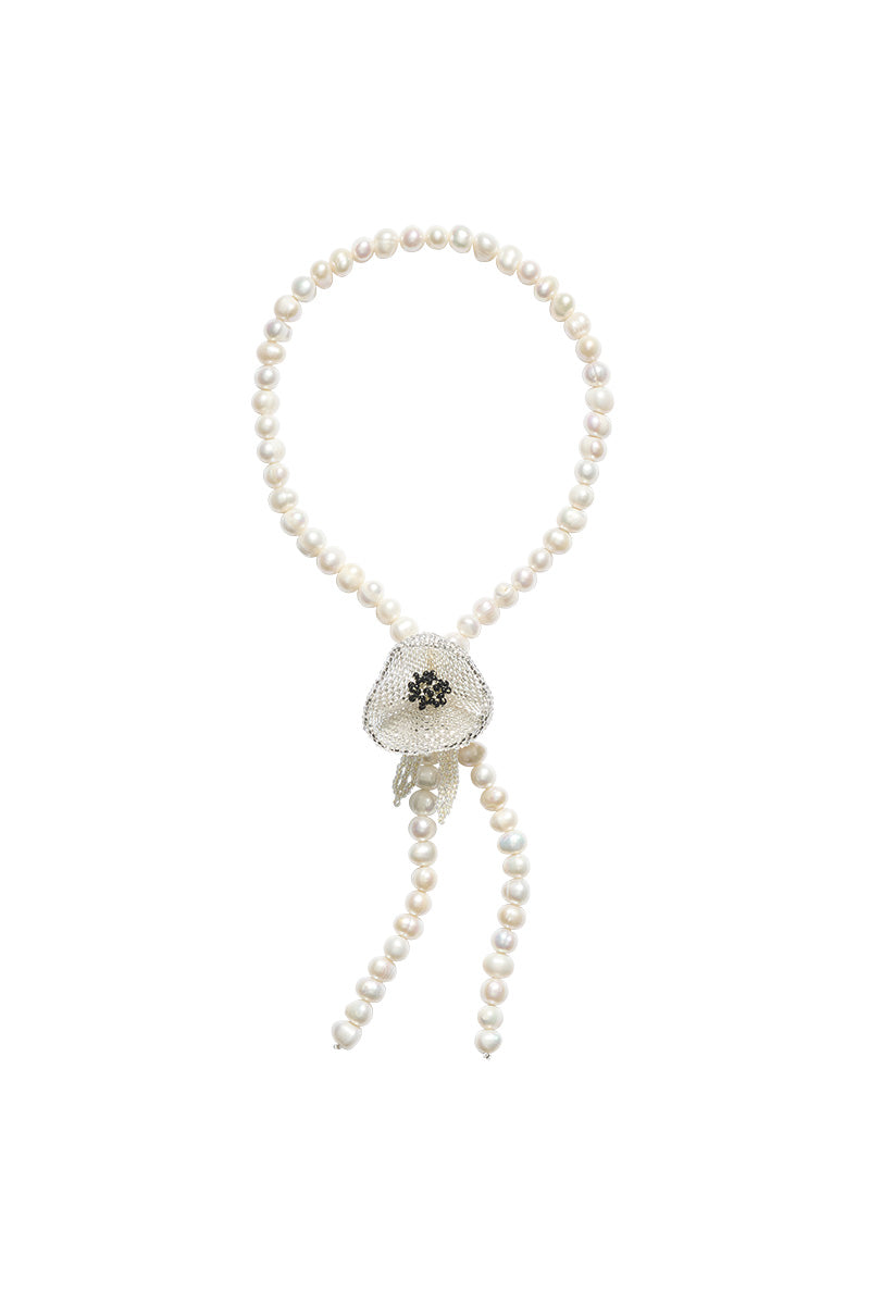 White Poppy Texas tie necklace by Pura Utz, featuring a delicate floral design on a stylish necklace chain.