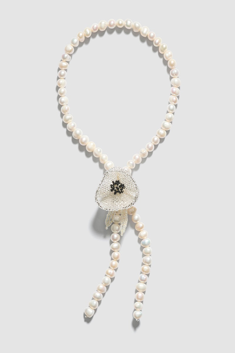 White Poppy Texas tie necklace by Pura Utz featuring lace design, styled as a fashionable accessories for casual or elegant outfits.