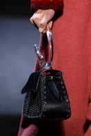 Black leather BOMBON top handle bag by JC Pajares featuring a Murano glass handle and elegant craftsmanship.