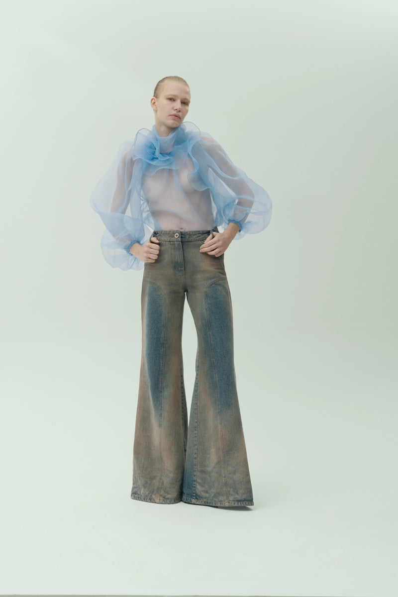 NADYA DZYAK flared jeans in rusty denim with a high waist and wide leg silhouette, model showing front view.