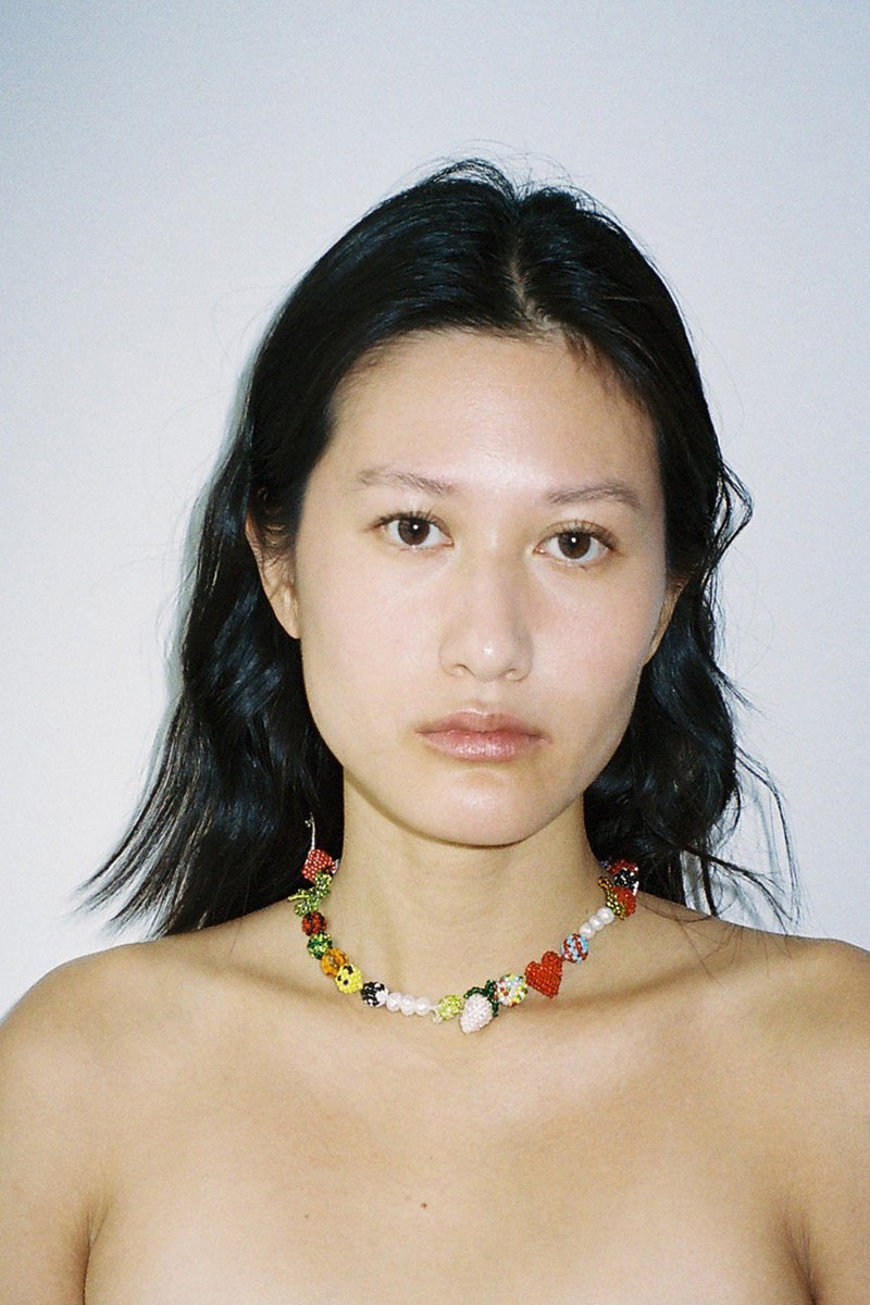 Pura Utz "Un Poco Loco" necklace featuring colorful beads and pendant, displayed on a neutral background.