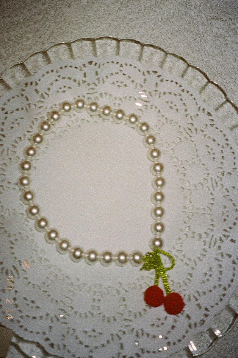 Pura Utz Mother of Cherry Necklace featuring a delicate cherry pendant on a silver chain, elegant and stylish jewelry accessory
