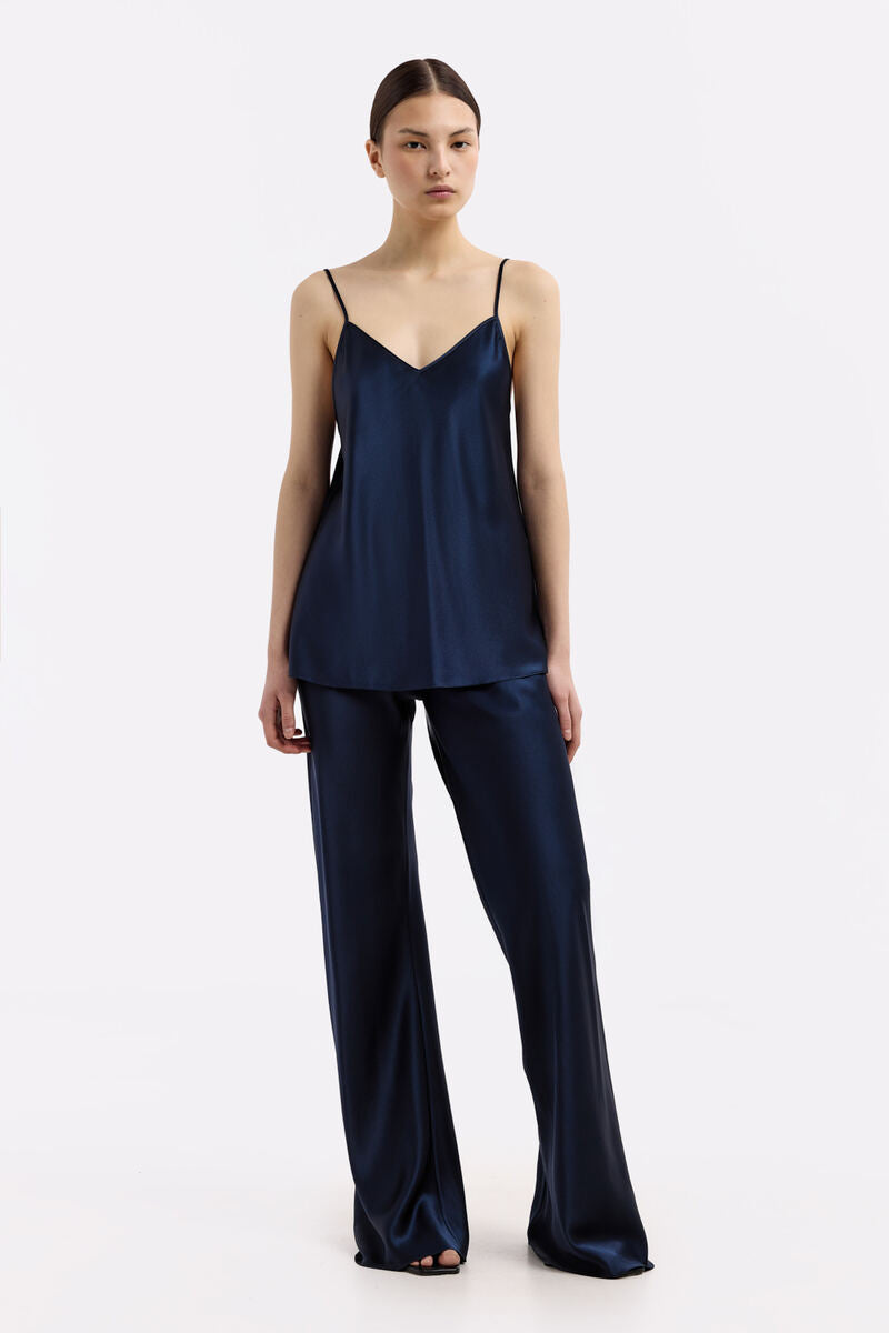 Serenity Paco navy V-neck silk satin cami top displayed on a hanger, showcasing smooth fabric and elegant design.