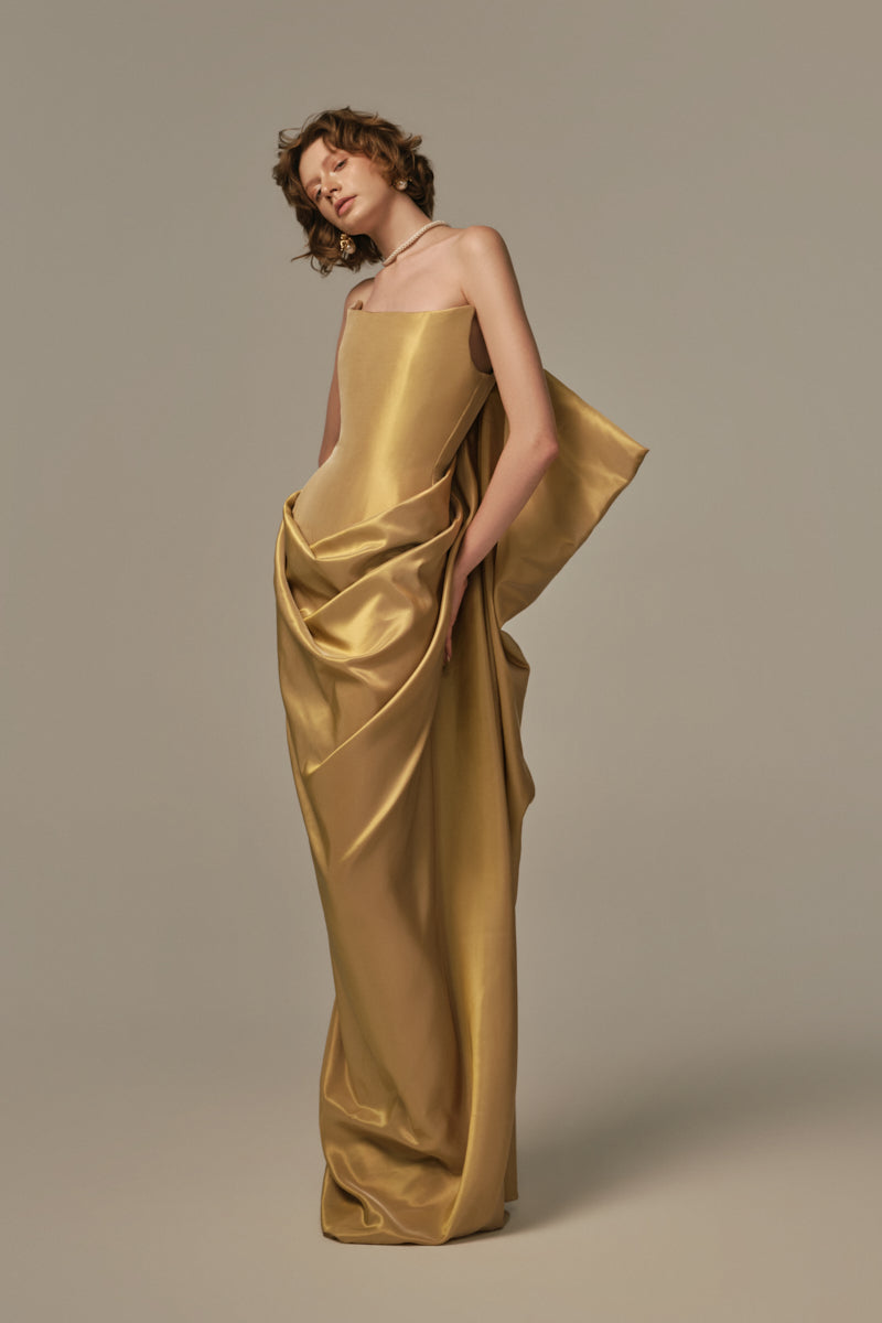 Elegant Palais gown by POEM featuring intricate golden fleece fabric and flowing design, showcased on a model.