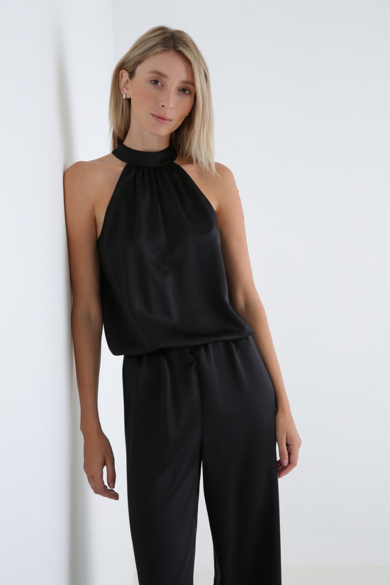 Serenity Palermo black silk-satin halter jumpsuit displayed on a hanger, featuring a sleek design and halter neckline.