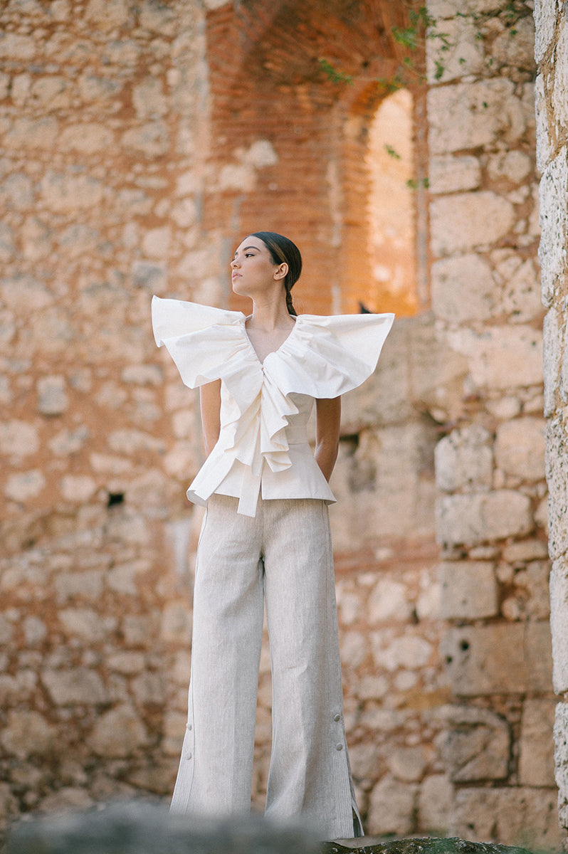 Ivory Palma blouse from ANA + MARIA, stylish tops with a flowy fabric and elegant design, shown in a campaign photo.