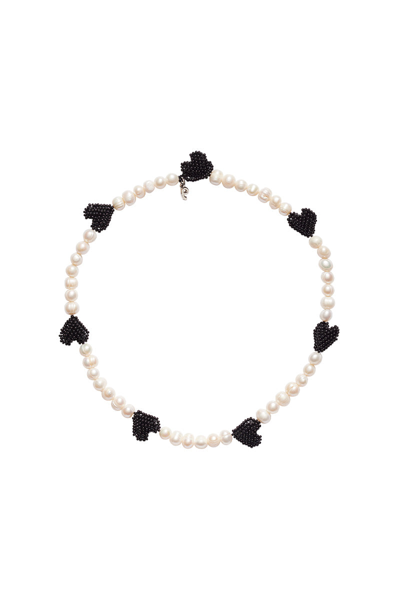 Black heart pendant necklace featuring multiple pearls, by Pura Utz, styled on a chain with elegant and modern design.