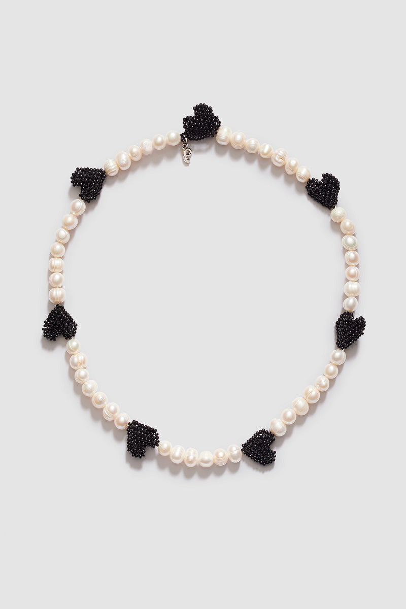 Pura Utz multi black heart necklace featuring black heart-shaped pendants and pearls on a delicate chain.