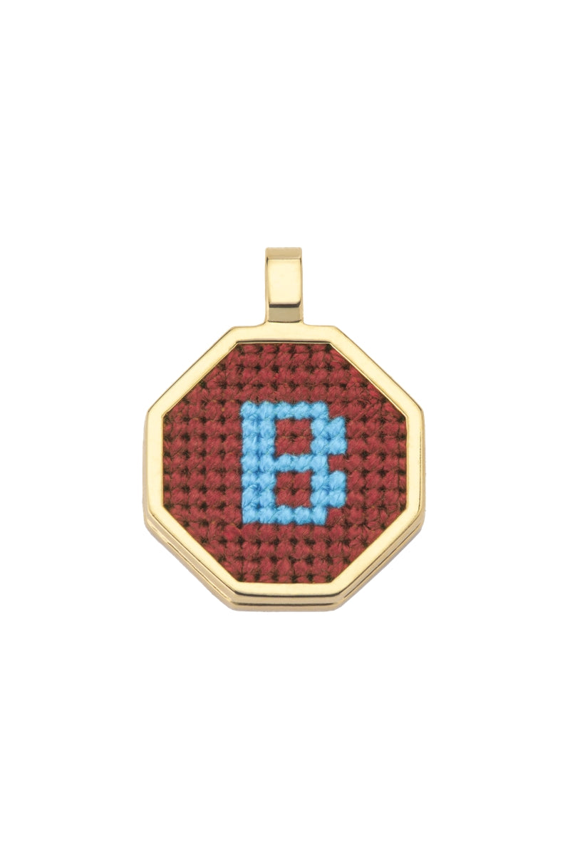 Personalised letter pendant necklace by Maria Frering featuring a brown leather cord and a custom engraved letter charm.