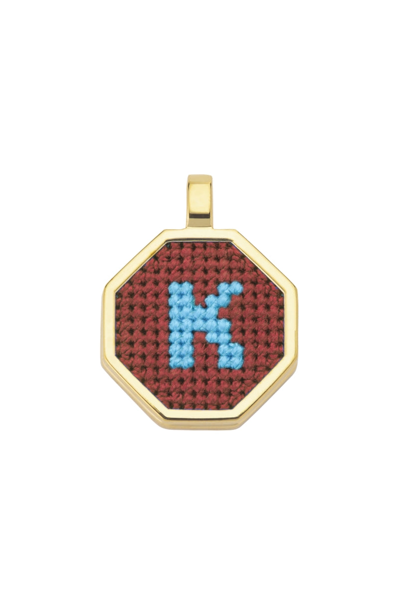 Personalised letter pendant necklace by Maria Frering featuring a brown leather cord and custom engraved initial charm.
