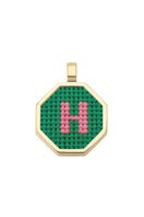 Personalised letter pendant necklace by Maria Frering with a green charm, close-up of the customized jewelry piece.