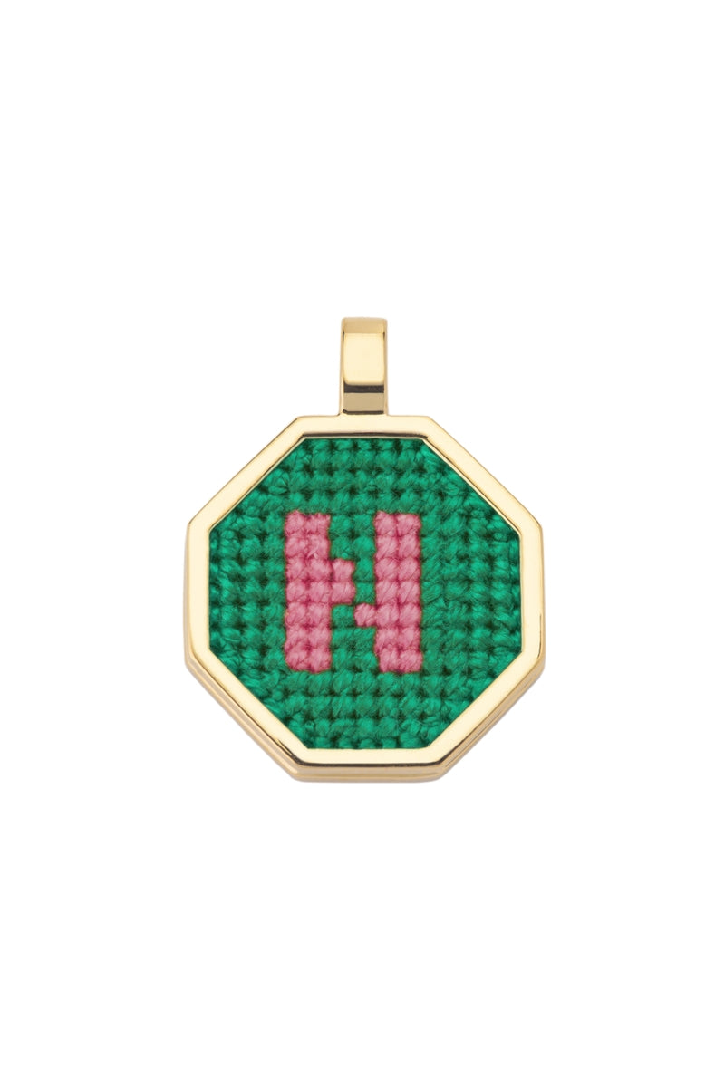 Personalised letter pendant necklace by Maria Frering with a green letter charm, stylish and elegant jewelry accessory.