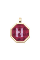Personalised letter pendant necklace by Maria Frering with a red pendant, showcasing a custom engraved letter on the jewelry.