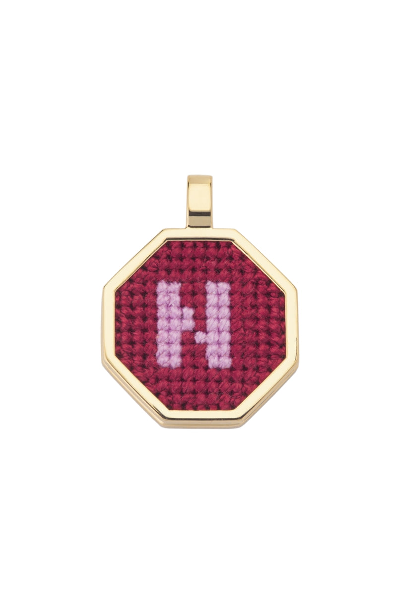 Personalised letter pendant necklace by Maria Frering with a red pendant, showcasing a custom engraved letter on the jewelry.