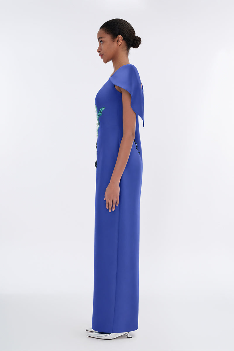 Tiny Ink Petal's Secret Dance asymmetrical cape evening gown featuring flowing fabric and elegant design, displayed on a model.