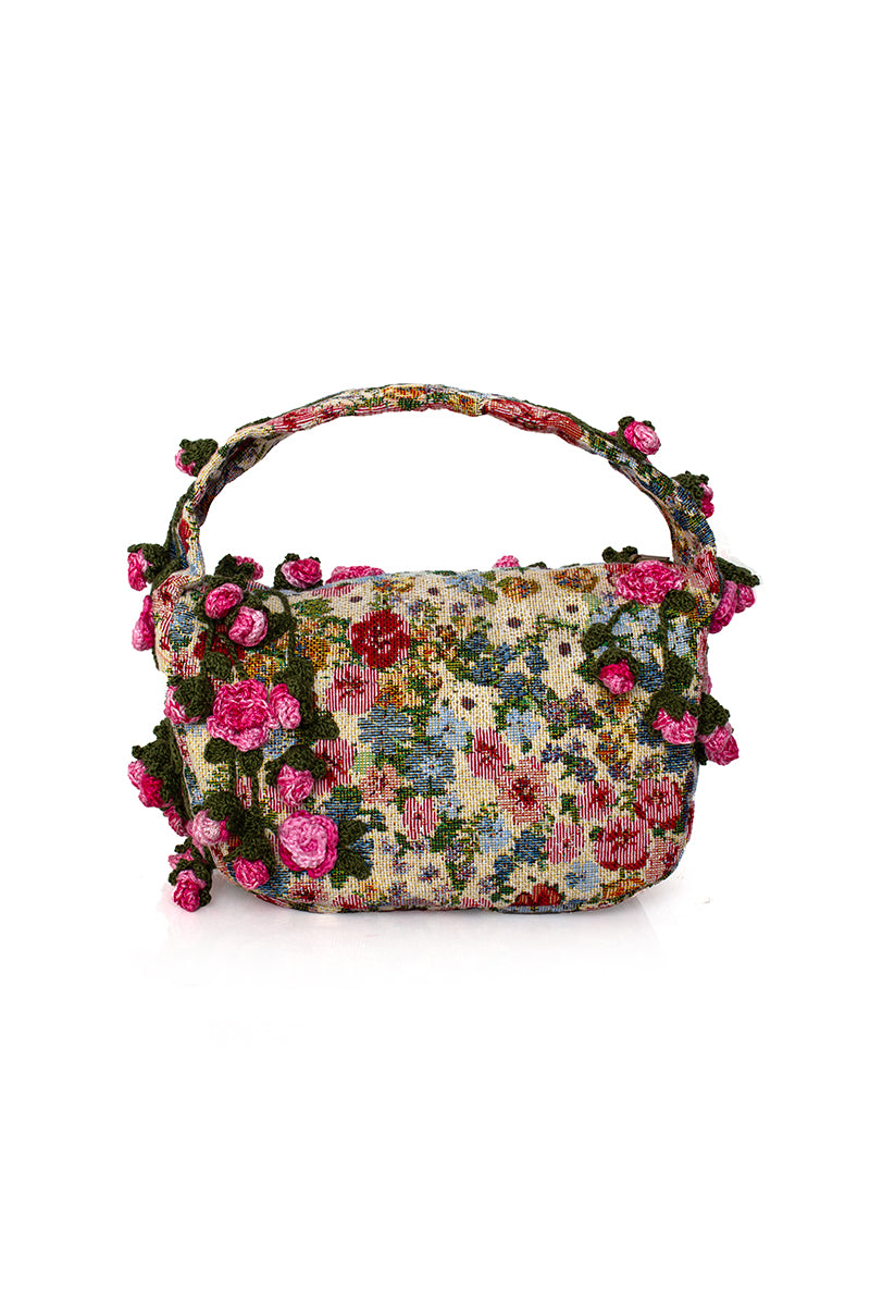 Pink top handle bag with pink roses design on Sarah's Bag Le Petit collection, featuring floral accents and elegant craftsmanship.