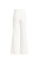 Cream-colored Pino Pants in ivory by ANA + MARIA, shown hanging on a wooden rack with a relaxed fit and minimalist style.