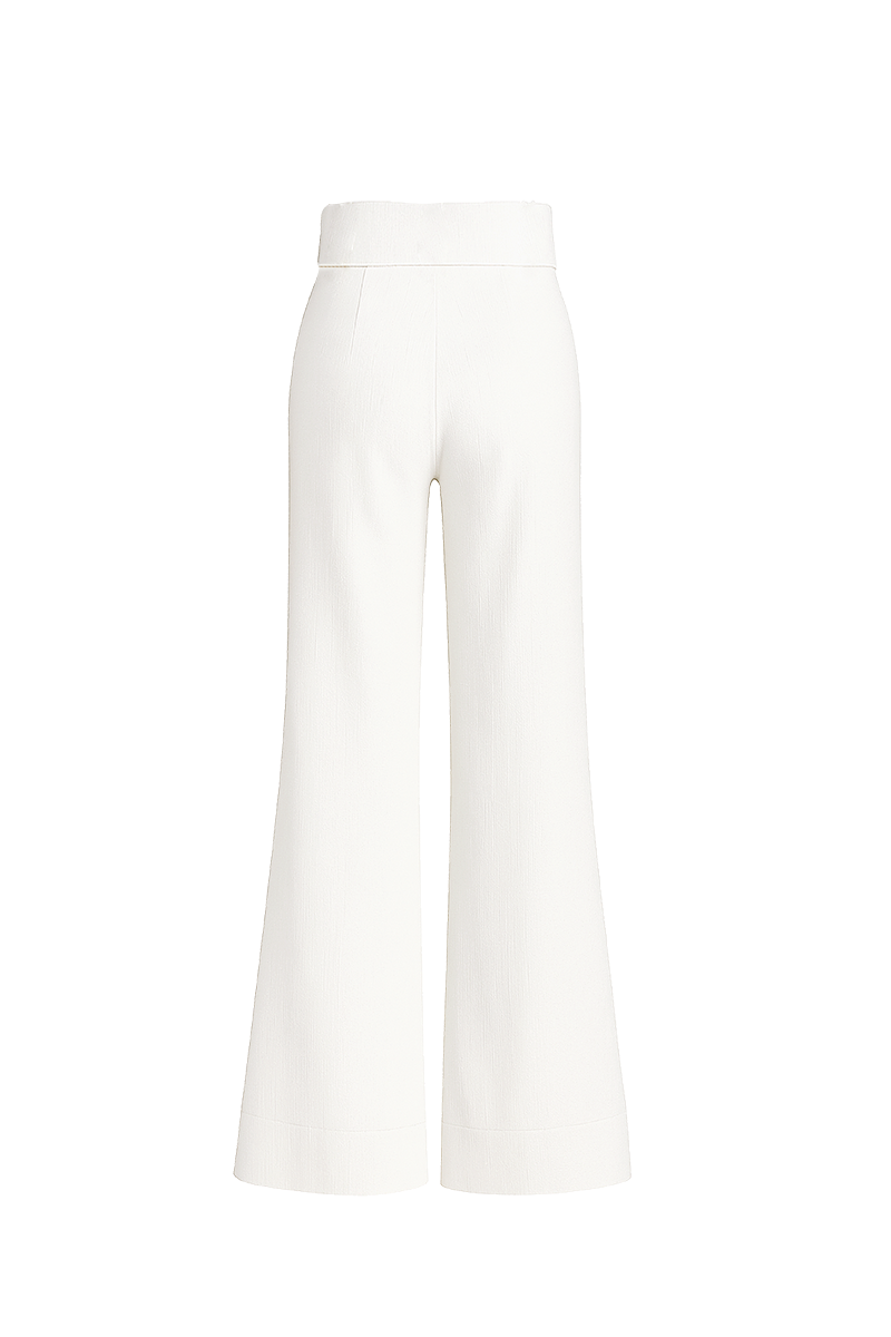 Cream-colored Pino Pants in ivory by ANA + MARIA, shown hanging on a wooden rack with a relaxed fit and minimalist style.