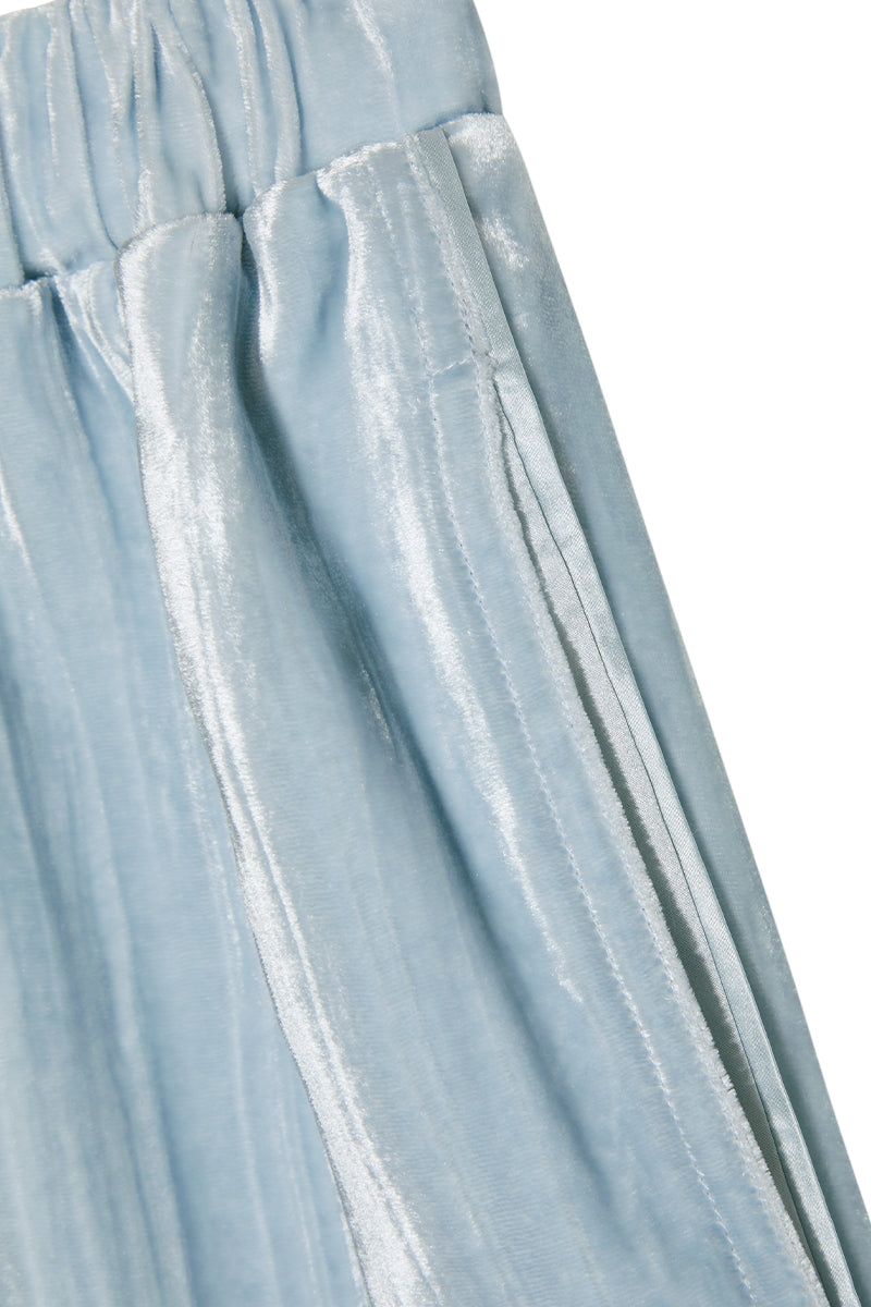 Blue velvet lounge set with pleated details, comfortable pajamas by MANITO, shown on a model in a relaxed indoor setting.