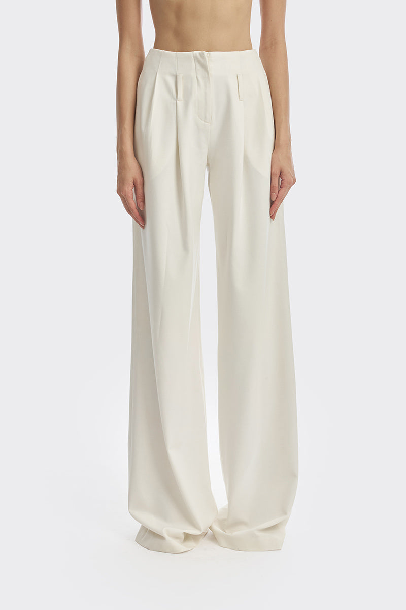 Off-white pleated trousers by Stolen Stores featuring a relaxed fit and tailored design, shown in a beige fabric.