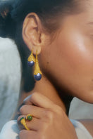Blue plunge earrings by Jude Benhalim featuring gold accents, displayed on a white background with a sleek, modern design.